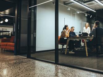 people working together in meeting room with glass wall